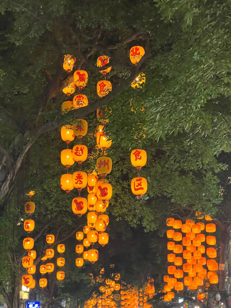 Street lined with glowing Chinese lanterns at night in Guangzhou, China - travel photography by Sakine Gulec